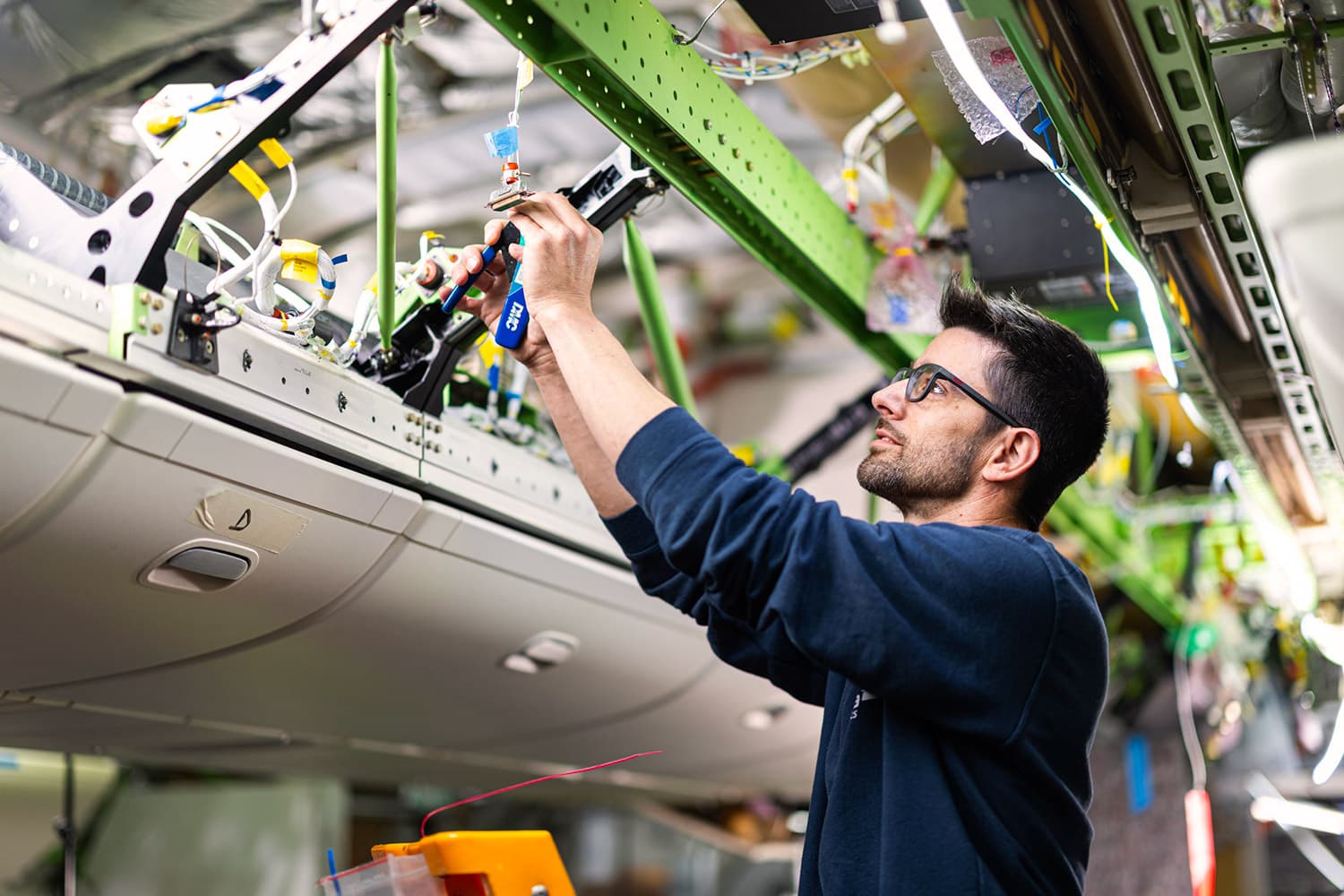 A Sabena technics wiring technician working on aircraft cabling inside the fuselage