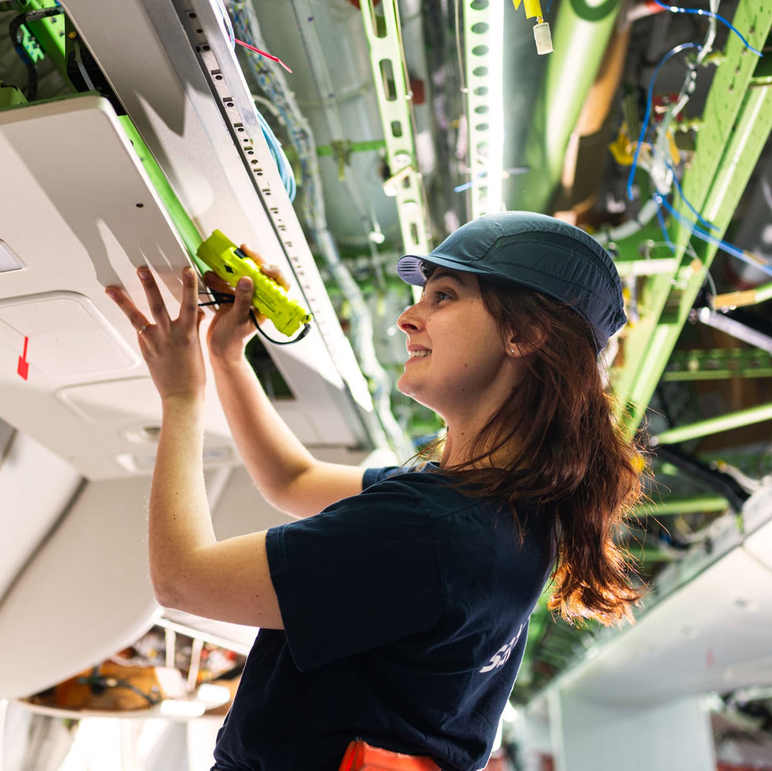 Technicienne cabine inspectant l’intérieur d’un avion