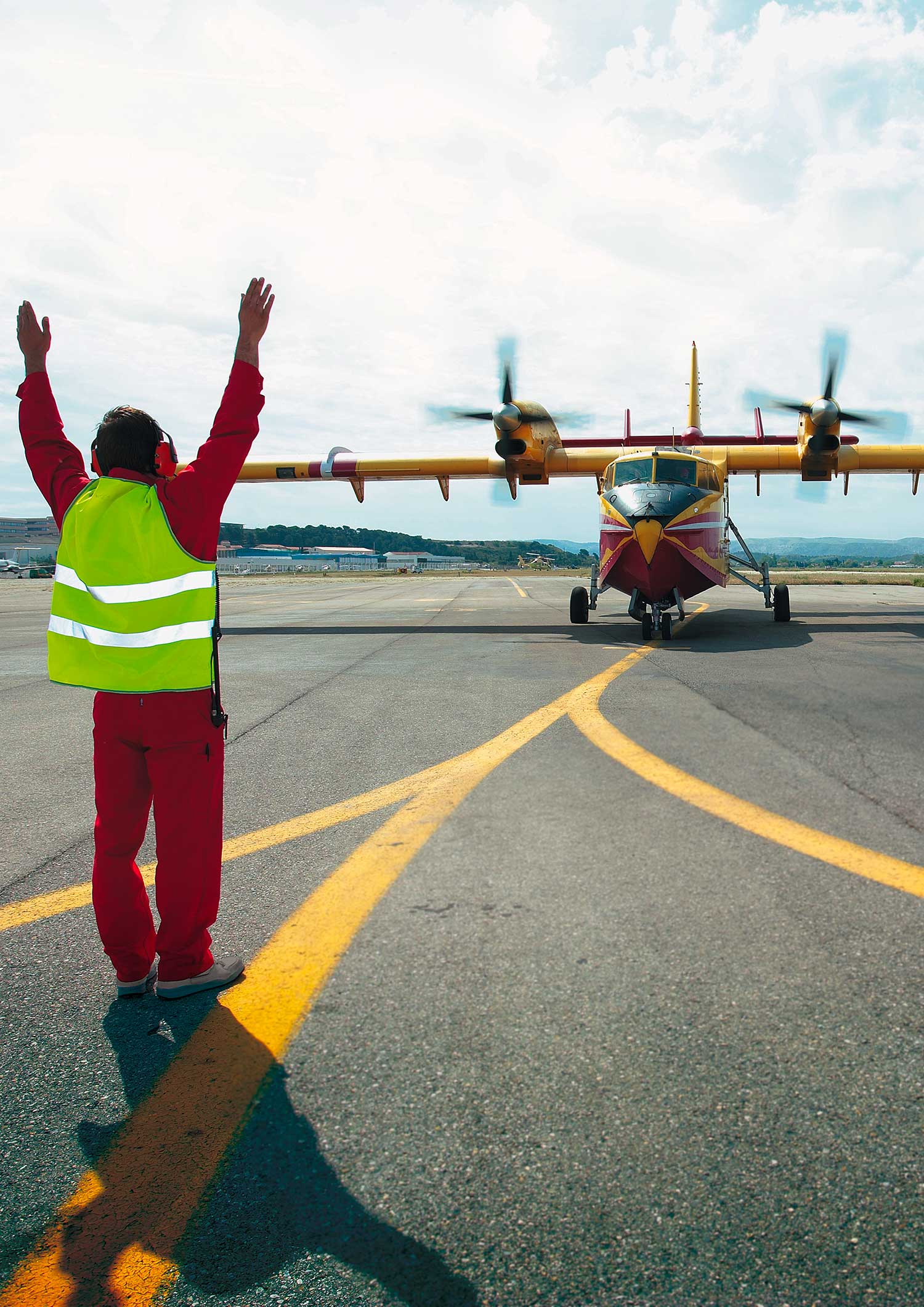 Civil Protection officer guiding a CL-415 Canadair on the tarmac