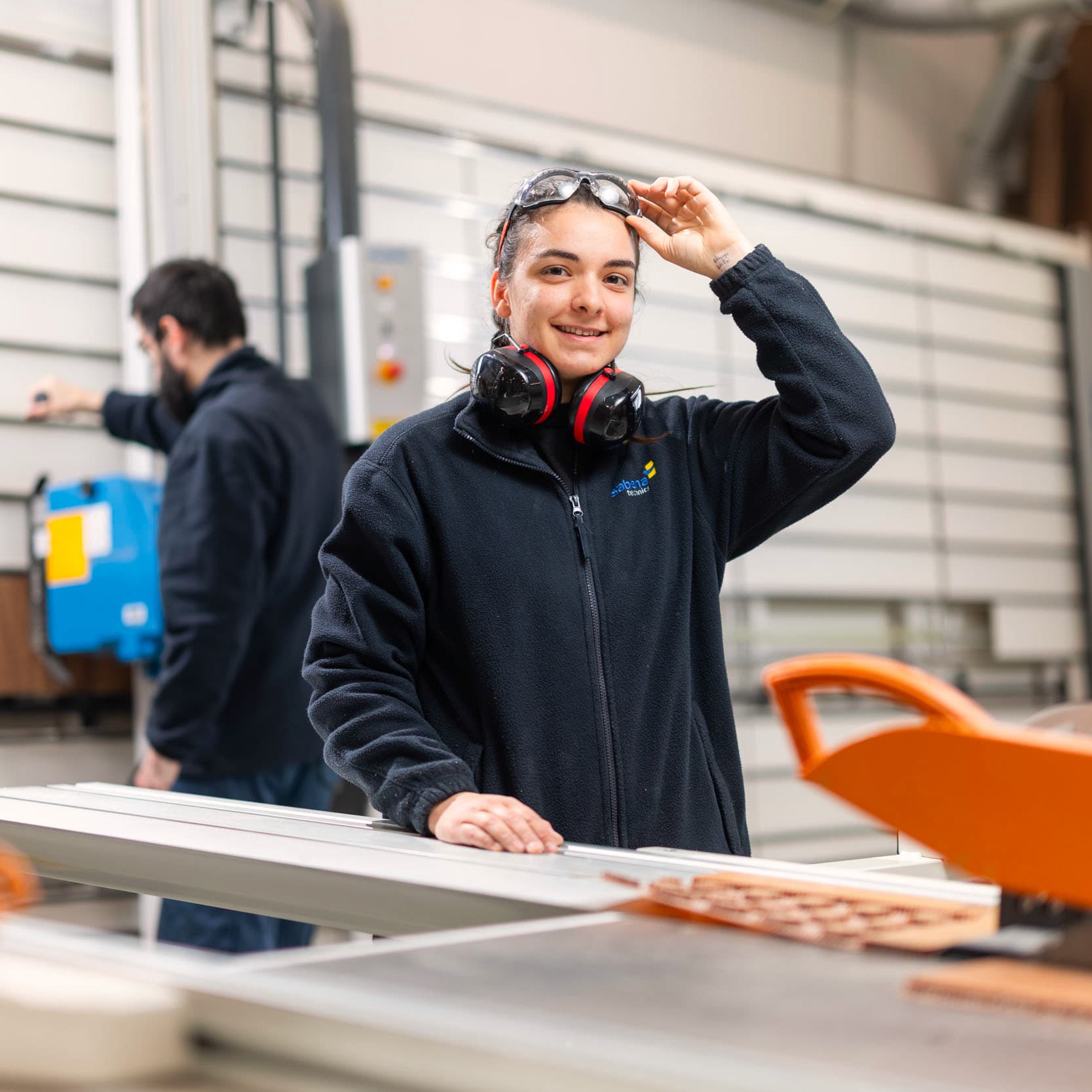 Menuisière/ébéniste aéronautique devant une scie circulaire