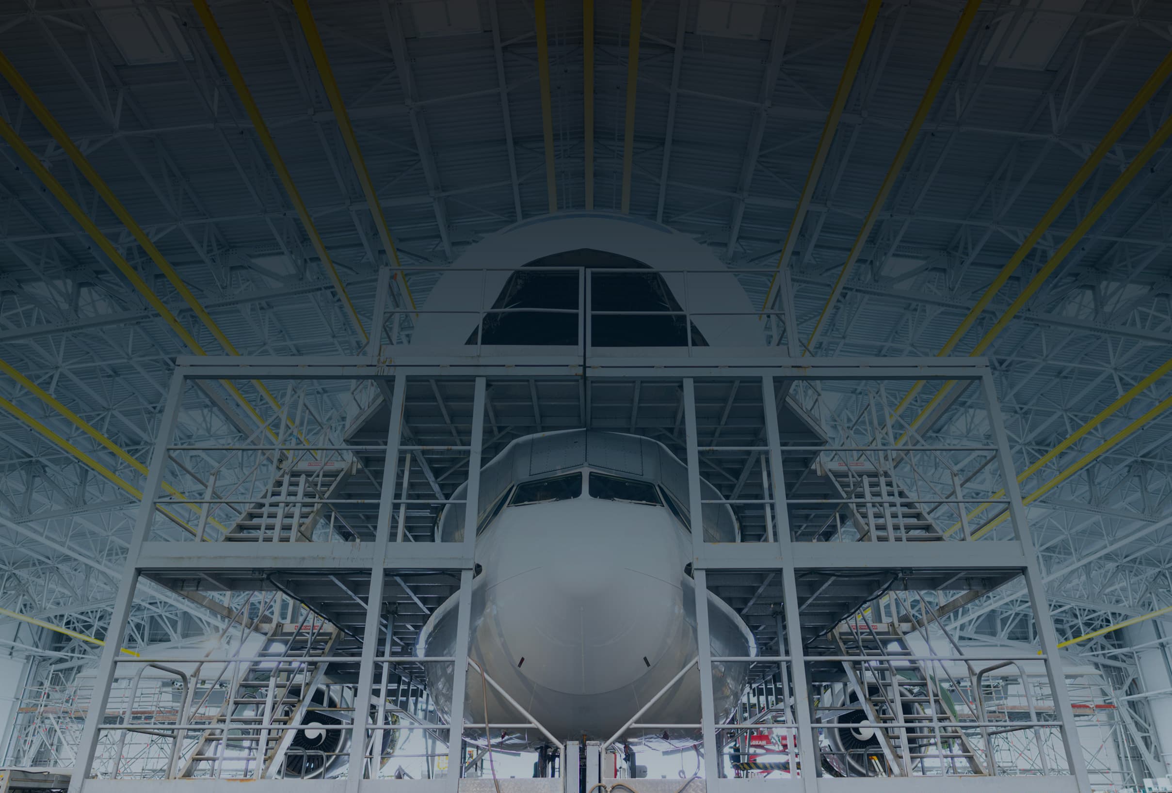 Commercial aircraft undergoing maintenance in a Sabena technics hangar, surrounded by metal scaffolding