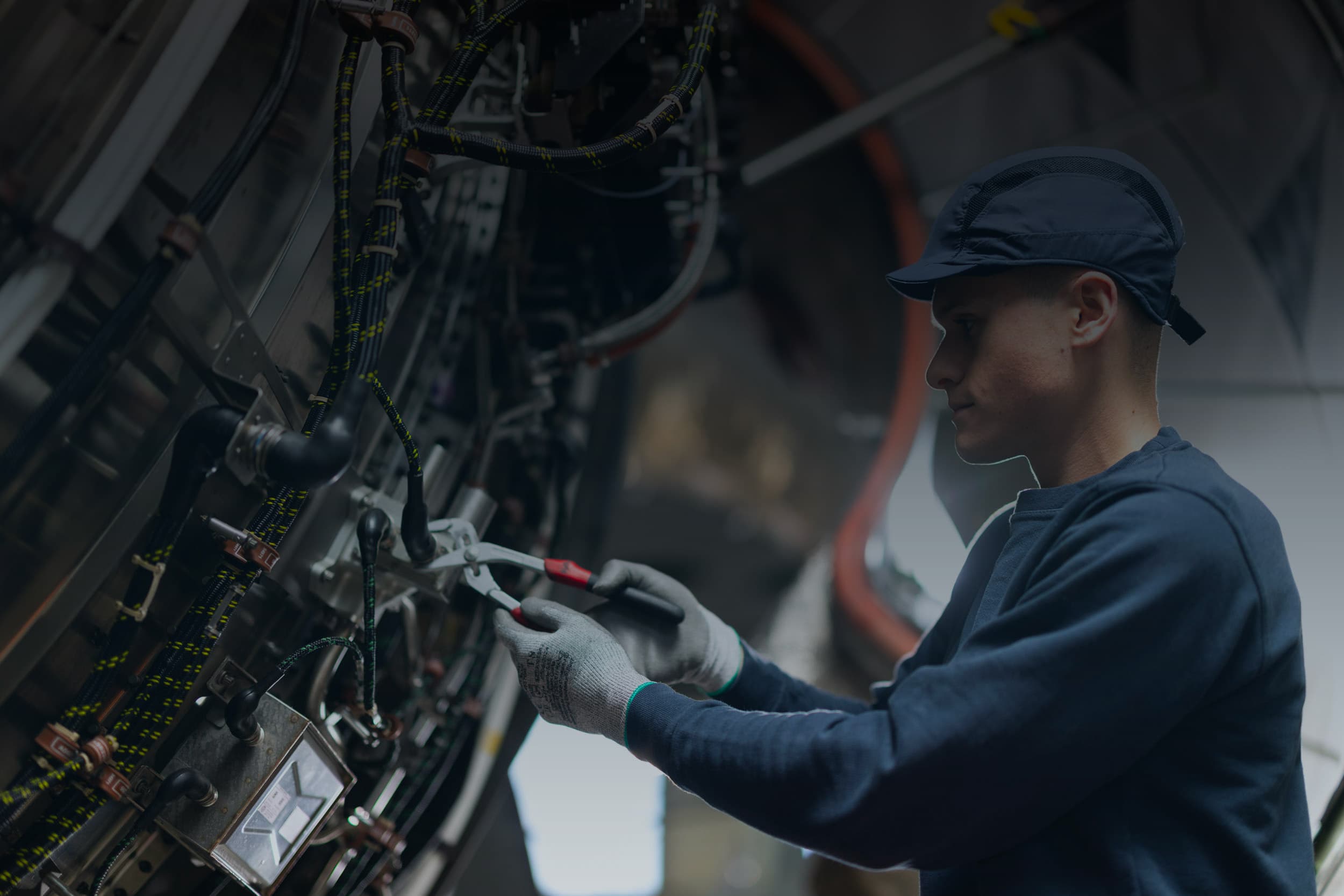 Technicien Sabena technics intervenant sur un système câblé complexe à l’intérieur d’un avion