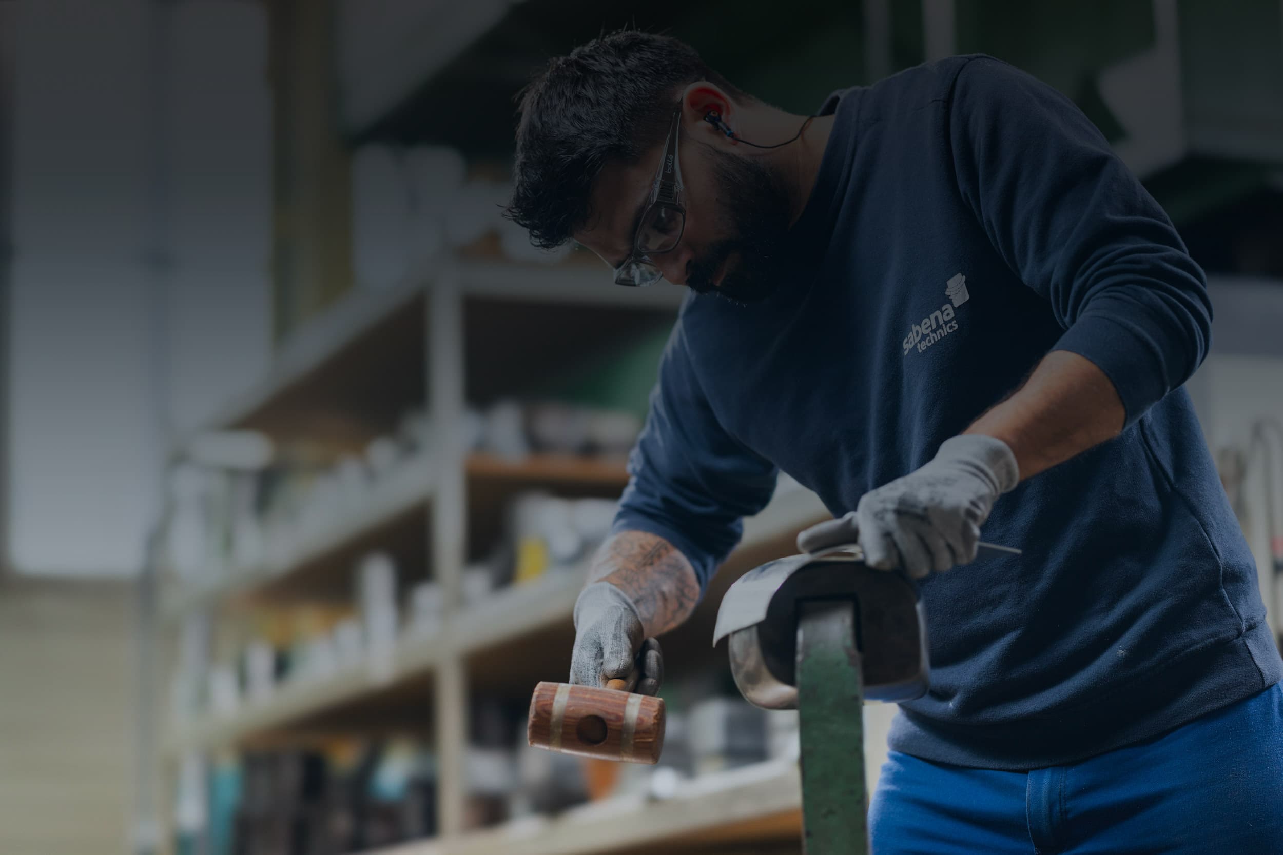 Technicien Sabena technics effectuant un ajustement manuel sur une pièce en atelier