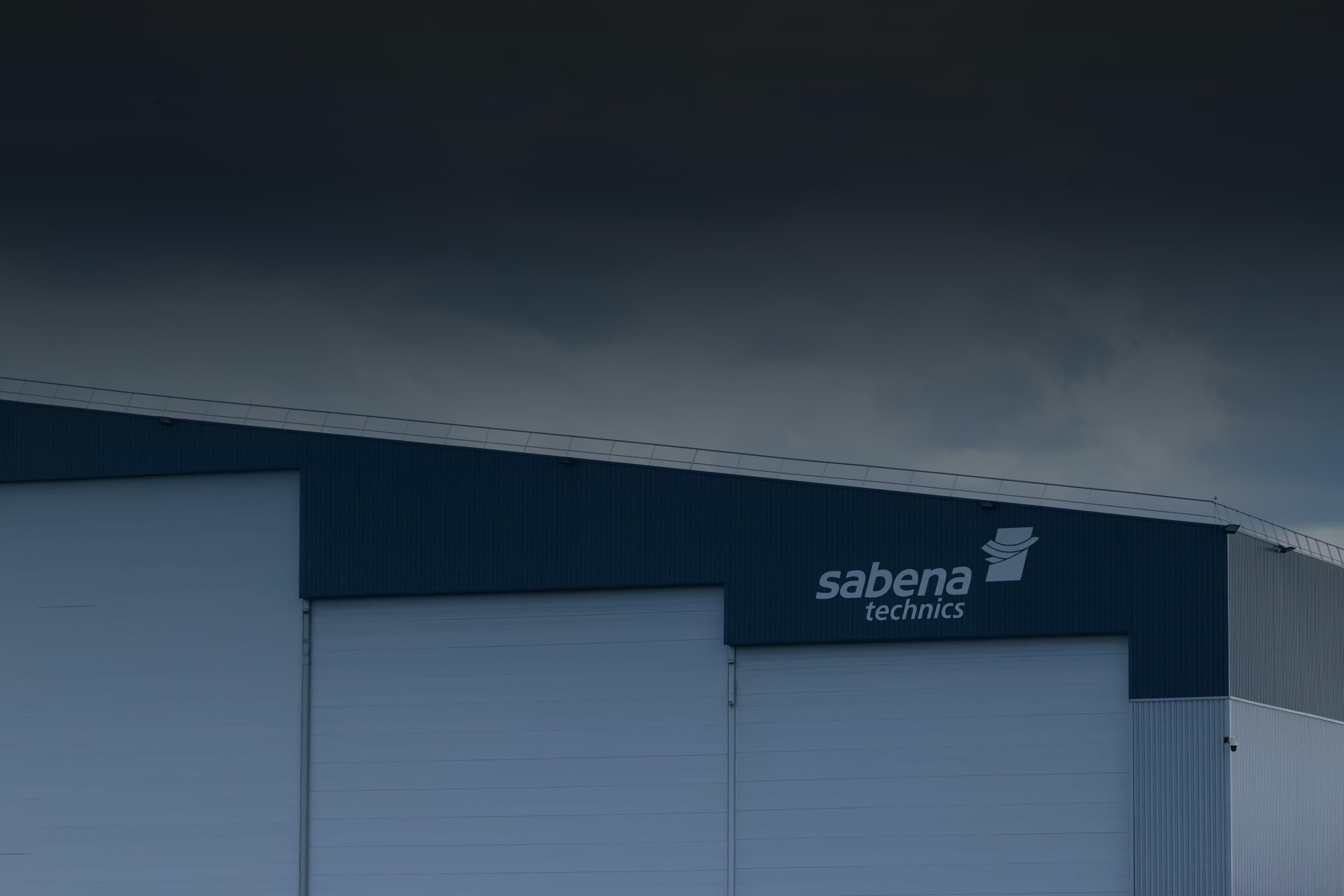 Exterior view of a Sabena technics maintenance hangar with visible logo on the façade